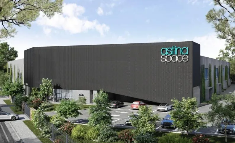 Architectural render of the Astina Space building: a black facade with teal signage above landscaped parking