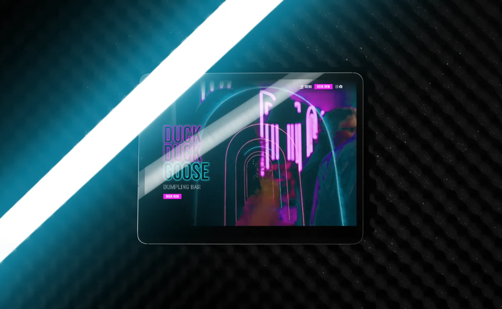 Duck Duck Goose dumpling bar website on a tablet, glowing in the brand's neon pink and teal
