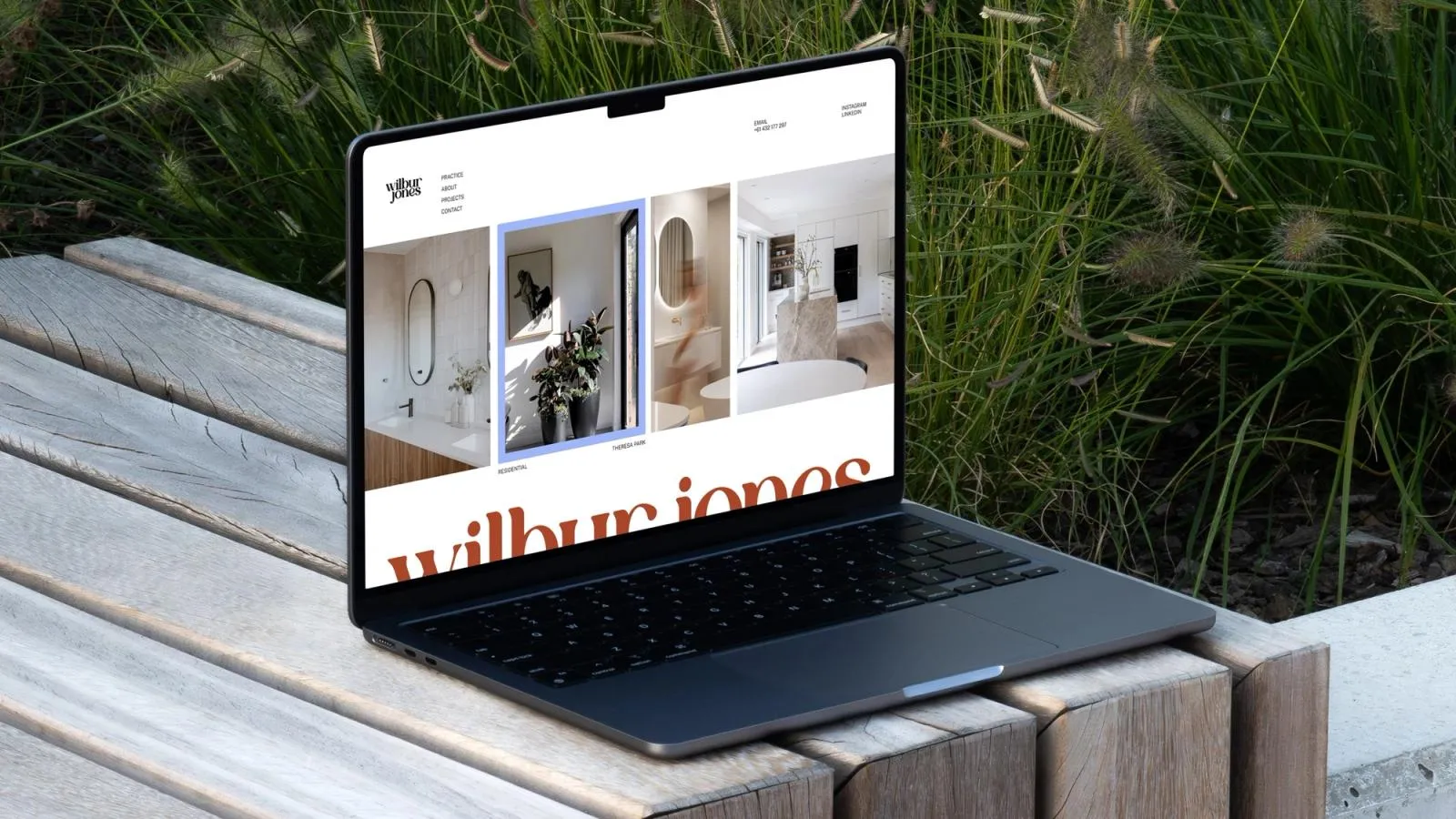 Wilbur Jones website on a laptop resting on an outdoor bench, showing bathroom and kitchen project photos
