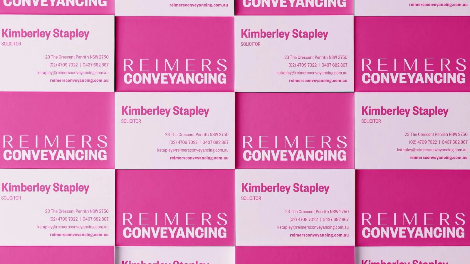 Grid of hot pink and white Reimers Conveyancing business cards for the firm's solicitor