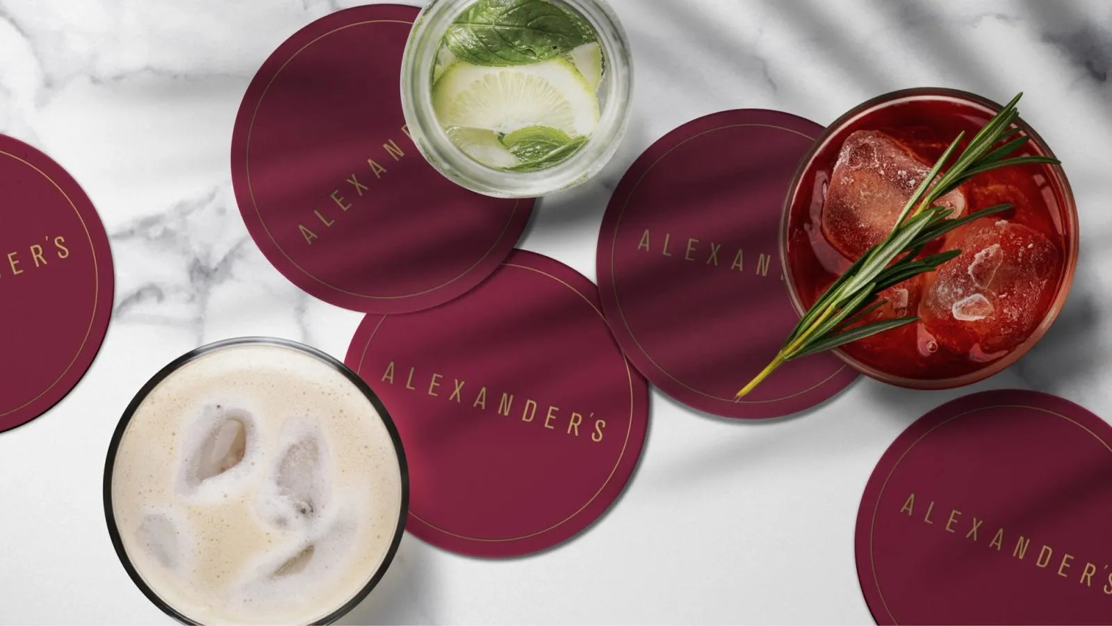 Burgundy Alexander's coasters under cocktails on a marble bar top