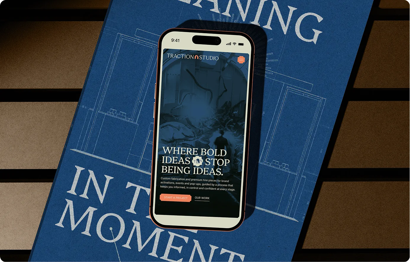 Traction Studio website on mobile over a brand poster